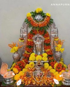 the altar is decorated with flowers, candles and an idol on it's stand