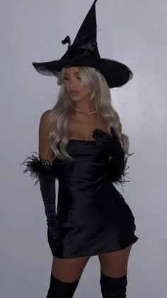 a woman in a black dress and witch hat