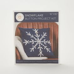 the snowflake pillow project kit is shown in front of a brown chair and white background