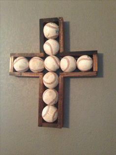 a cross made out of baseballs is hanging on the wall