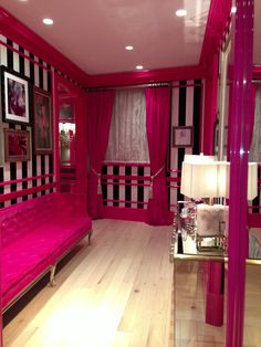 the room is decorated in pink and black with pictures on the walls, flooring