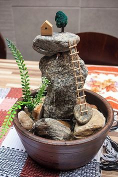 there is a rock garden with a ladder in the middle and a house on top