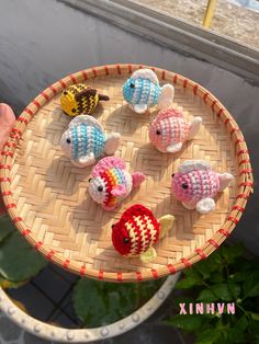 small knitted fish sitting on top of a wooden tray