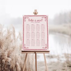 a wooden easel with a sign that says take a seat next to the water