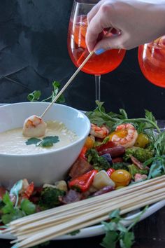 a person dipping some food into a bowl