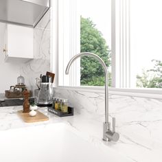 a white kitchen with marble counter tops and stainless steel faucet in the middle