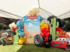 cars and balloons are on display under a tent