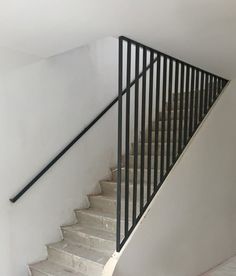 there is a white staircase with black railings