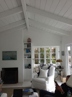 a living room filled with furniture and a fire place next to a wall mounted book shelf