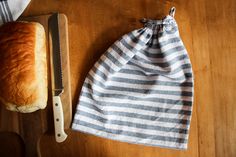 a loaf of bread sitting on top of a wooden cutting board next to a knife