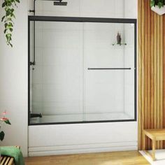 a bathroom with a wooden bench next to a glass shower door that is sliding open