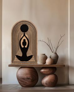 a wooden table topped with vases sitting next to a painting on top of it