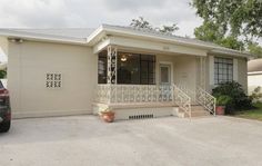 a car parked in front of a house with a porch and railings on it