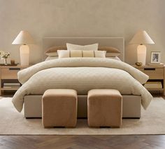 a large bed with two foot stools in front of it