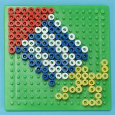 an image of a lego bird made out of beads on a green board with red, white and blue circles