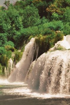 a man riding a surfboard on top of a waterfall