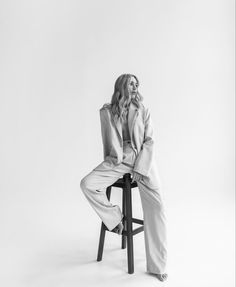 a woman sitting on top of a stool