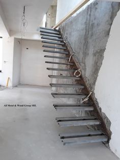 an empty room with concrete walls and stairs