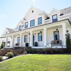 a large white house sitting on top of a lush green field