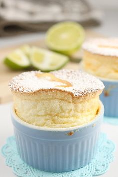 two cupcakes with powdered sugar on top and lime slices in the background