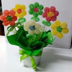 a vase filled with gummy bears sitting on top of a white table next to a green bow