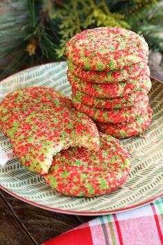 christmas sprinkle cookies are stacked on a plate