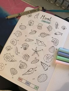 an open notebook with doodles and pencils on it