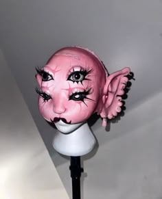 a close up of a pink mask on a stand