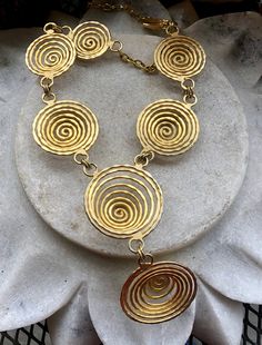 Modernist Egyptian Revival Gold Gilt Coil Spiral Vintage Bib Necklace Necklace is adjustable , measures 16 inches around the neck the front drop measures over 2 inches Beautiful, well done Elegant Adjustable Swirl Necklace, Adjustable Metal Swirl Jewelry, Artisan Spiral Metal Jewelry, Bohemian Gold Swirl Jewelry, Handmade Adjustable Spiral Necklace, Bohemian Spiral Metal Necklace, Handmade Spiral Metal Necklace, Unique Swirl Shaped Metal Jewelry, Unique Swirl Metal Jewelry