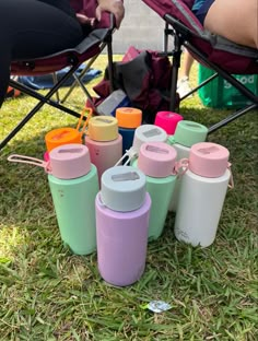 thermos are lined up on the grass for people to sit in their chairs