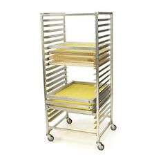 a metal rack with four trays on wheels and yellow paper in the bottom drawer