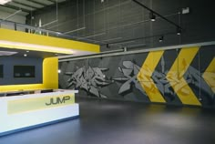 an empty room with graffiti on the wall and yellow counter top in front of it