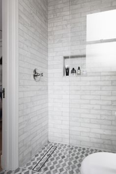 a bathroom with a checkered tile floor and white walls, along with a walk in shower