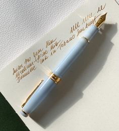 a fountain pen sitting on top of a piece of white paper with writing on it