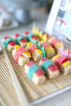 there are many small treats on the bamboo tray with toothpicks in each one