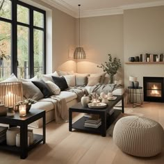 a living room filled with furniture and a fire place in front of a large window