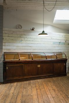 an empty room with two benches and a light fixture hanging from the ceiling above it