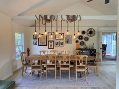 a dining room table and chairs with pictures on the wall above it in an open floor plan