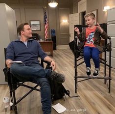 a man sitting in a chair next to a little boy