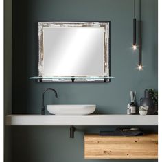 a bathroom sink with a mirror above it and lights on the wall next to it