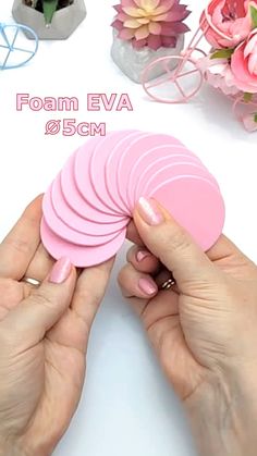 a person is holding pink foam coasters in their hands