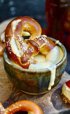 some pretzels are being drizzled with cheese and sauce in a bowl