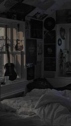 a bedroom with a guitar on the window sill