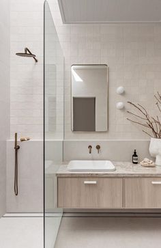 a bathroom with two sinks and a large mirror on the wall next to a walk in shower