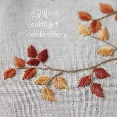 an embroidered piece with leaves on it and the words, safflight embroidery written in japanese