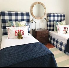 two beds in a bedroom with blue and white checkered headboards, one has a teddy bear on the bed