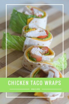 chicken taco wraps on a cutting board with lettuce and tomato in the middle