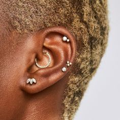 a close up of a person with ear piercings on their ears and behind the ear