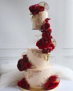 three tiered wedding cake with red roses on top