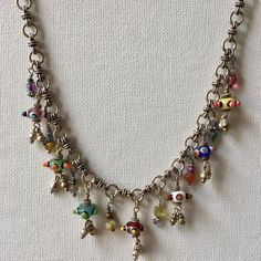 This Charm Necklace has Seven colorful Czech beads that are joined by ten of my treasure charms on a gorgeous hand made Silver Tribal Chain. This Artisan Necklace is whimsical and full of joy! A Boho Tribal Necklace, this beauty makes a bold statement. Treasure charms have beads, crystals, silver and pearls. Necklace measures 16 inches.  One of a kind! Charm Necklace, Silver Charm Necklace, Czech Glass Necklace, Artisan Necklace, Statement Necklace, Boho Necklace, Boho Jewelry Multicolor Czech Glass Necklace One Of A Kind, Handmade Artisan Pendant Charm Necklaces, Multicolor Metal Pendant Charm Necklaces, Artisan Jewelry With Czech Glass And Dangling Beads, Whimsical Multicolor Jewelry With Dangling Charms, Whimsical Multicolor Jewelry With Charms, Spiritual Multicolor Charms Jewelry, Whimsical Multicolor Charms Jewelry, Handmade Charm Necklaces For Festivals